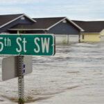 25th St SW direction sign floating above a flooded landscape