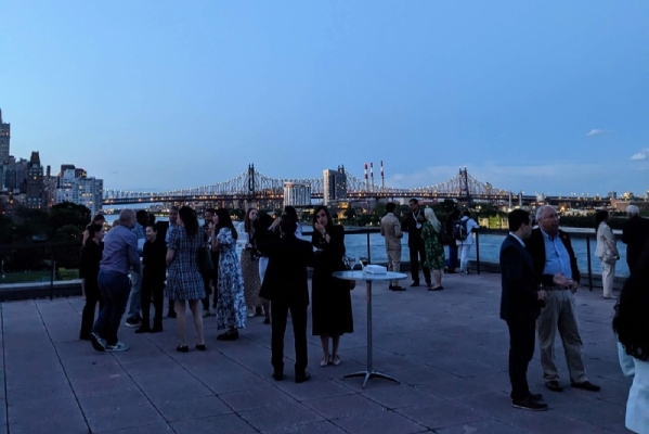 Attendees having multiple conversations outdoors at a reception at the United Nations Headquarters